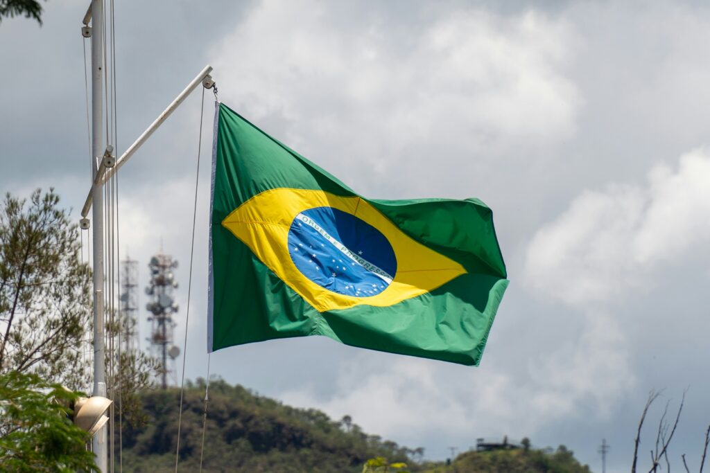 Bandeira do Brasil tremulando em um mastro ao ar livre.